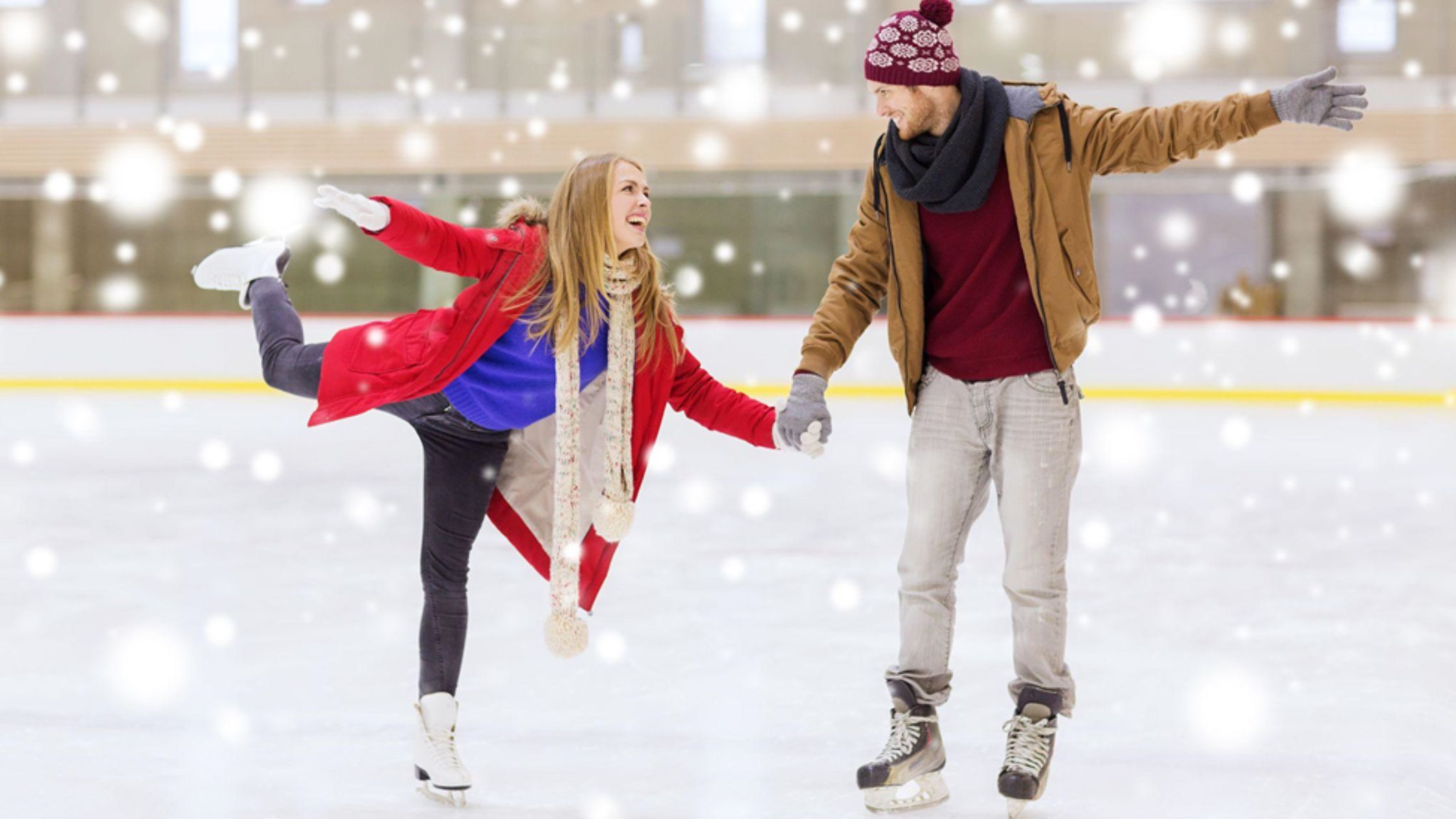 couple ice skating on ice skating rink smiling happy