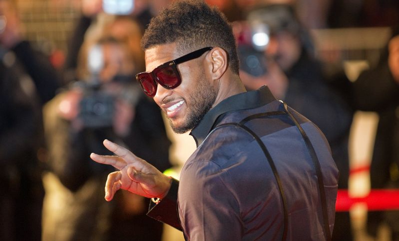 usher with glasses on showing the peace sign