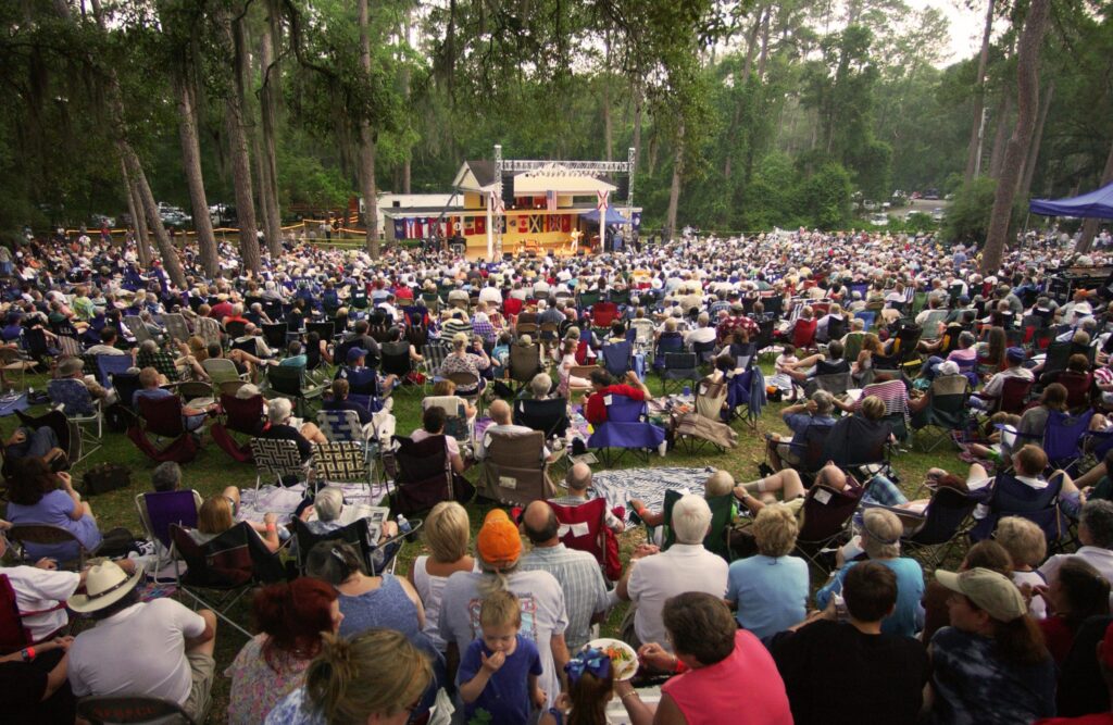 people sitting down on the grass listening to folk music in florida tallassahee