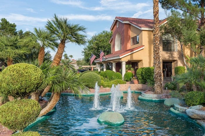 exterior view of westgate flamingo bay, palm trees, fountains, and clear skies