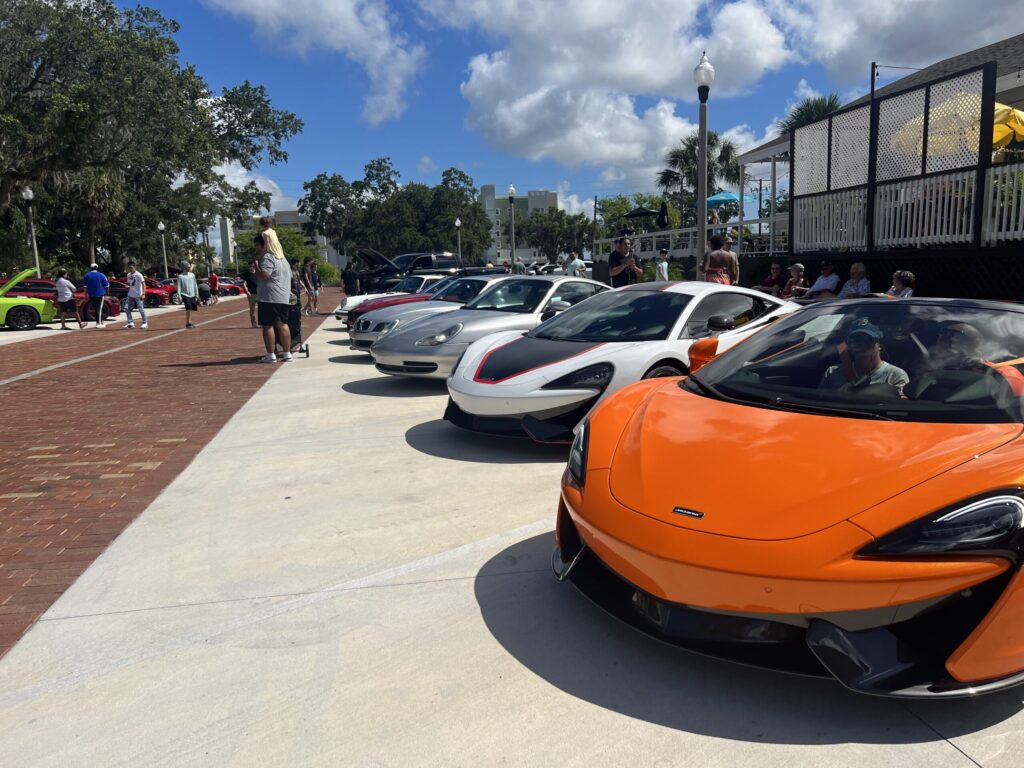 orange sports car, white sports car at a car show in orlando